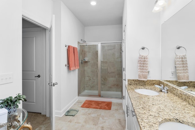 full bath featuring a stall shower, double vanity, tile patterned flooring, baseboards, and recessed lighting
