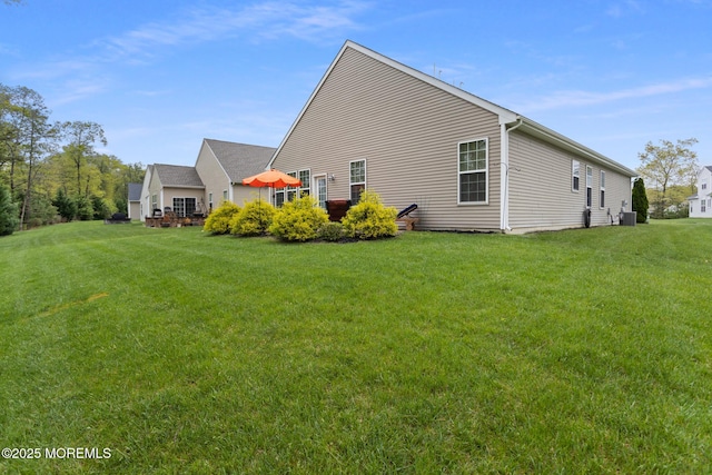 view of side of home featuring a yard and central air condition unit