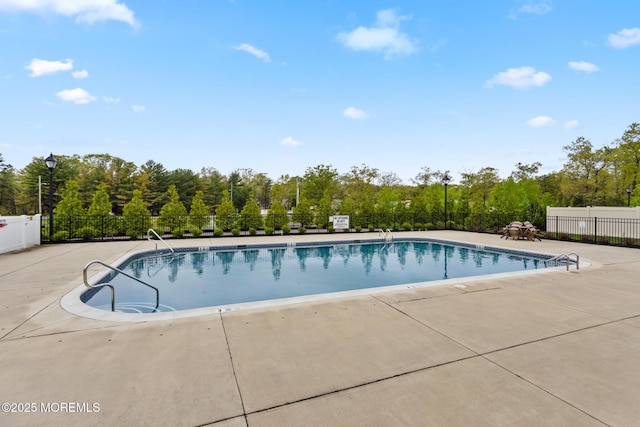 community pool featuring fence and a patio