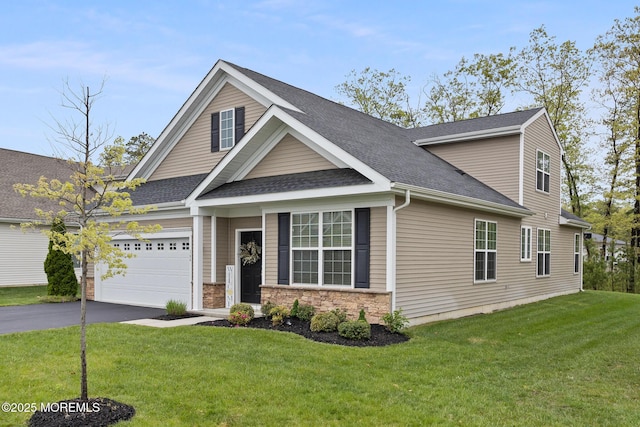 view of front of property with asphalt driveway, an attached garage, roof with shingles, and a front yard