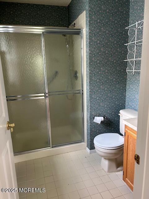 full bathroom with vanity, tile patterned floors, a stall shower, and toilet