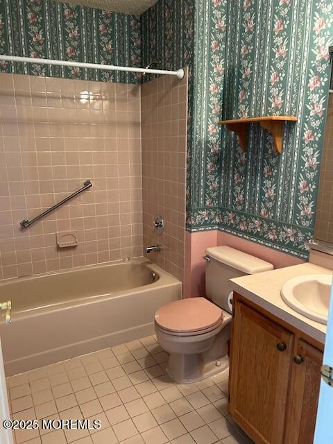 full bath featuring tile patterned flooring, vanity, toilet, shower / bathtub combination, and wallpapered walls