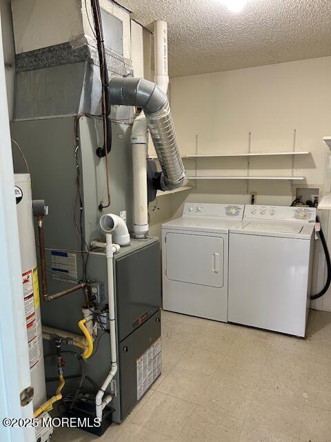 washroom featuring laundry area, a textured ceiling, independent washer and dryer, and water heater