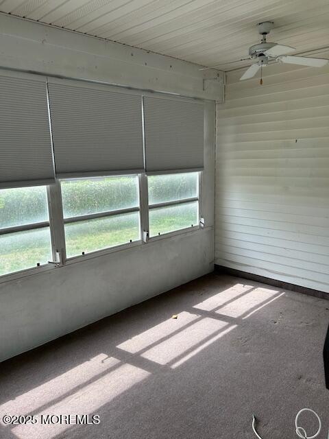 unfurnished sunroom featuring a ceiling fan