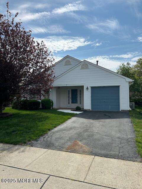 single story home featuring a garage, a front lawn, and aphalt driveway