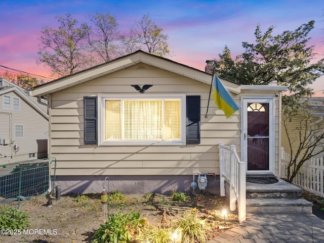 bungalow-style home featuring fence