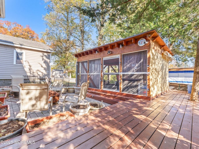 wooden deck with a fire pit and an outdoor structure