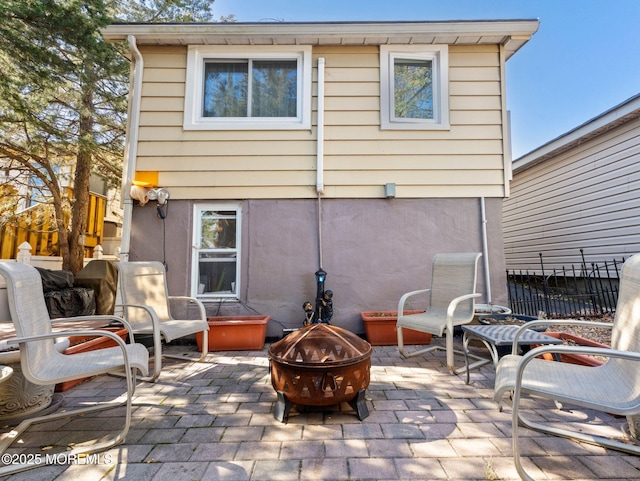 back of property featuring an outdoor fire pit and a patio