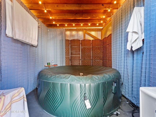bathroom with beamed ceiling, wooden ceiling, and concrete floors
