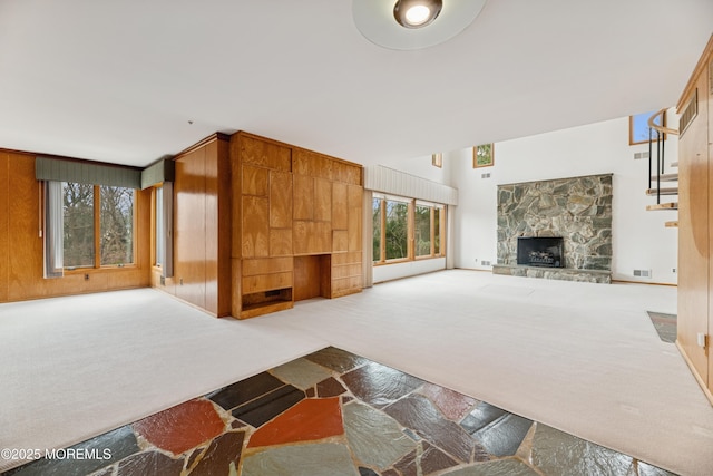 unfurnished living room with carpet and a stone fireplace