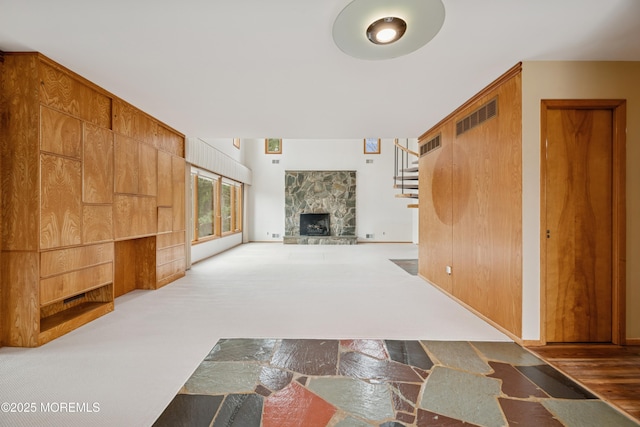 foyer entrance featuring stairs and a fireplace