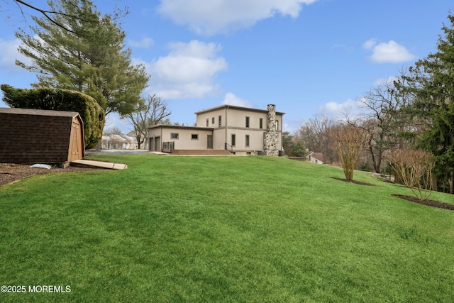view of green lawn featuring an outdoor structure and a shed