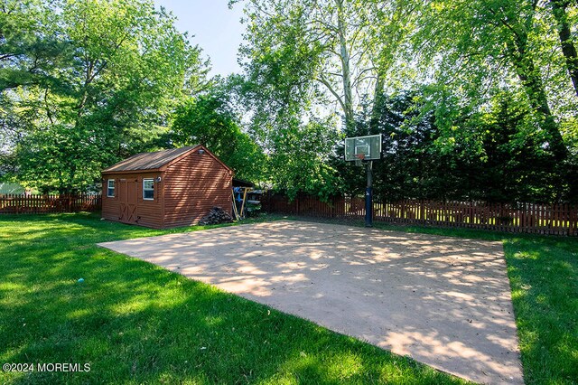 view of sport court featuring a fenced backyard and a yard