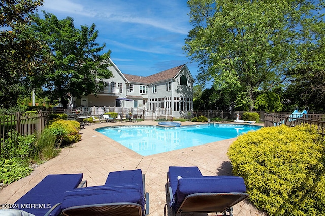 view of swimming pool featuring a fenced in pool, a diving board, fence, and a patio