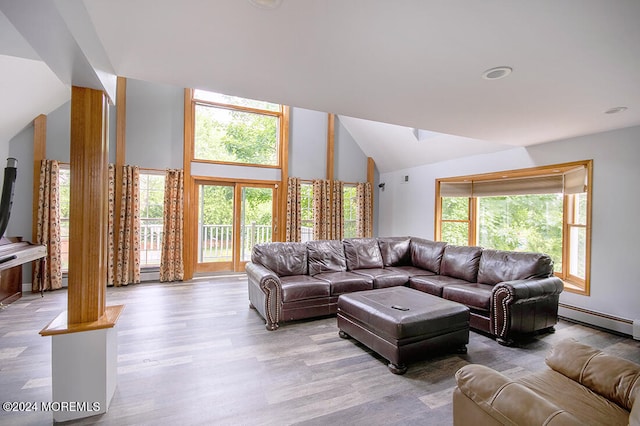 living area with a baseboard radiator, vaulted ceiling, and light wood finished floors