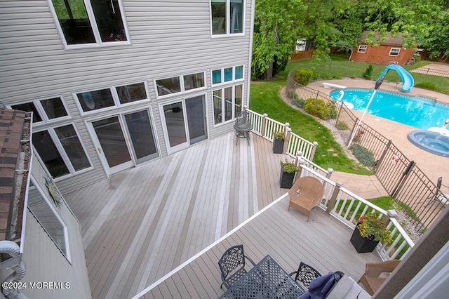 deck featuring a fenced in pool, fence, outdoor dining area, and a lawn