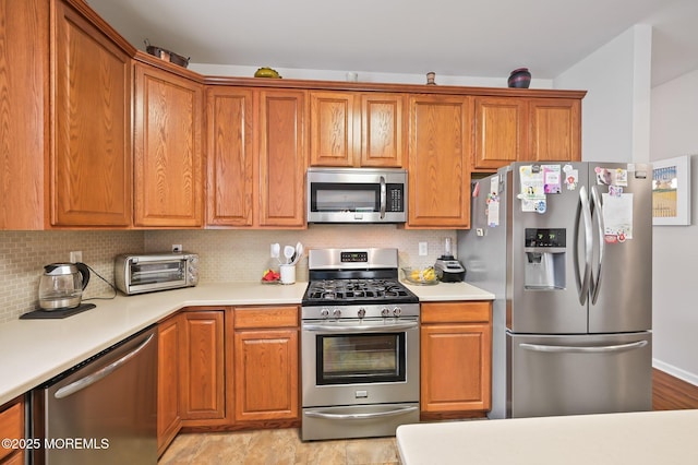 18 Hartack Rd, Manalapan, NJ 07726 - kitchen with appliances with stainless steel finishes, light countertops, backsplash, and brown cabinets