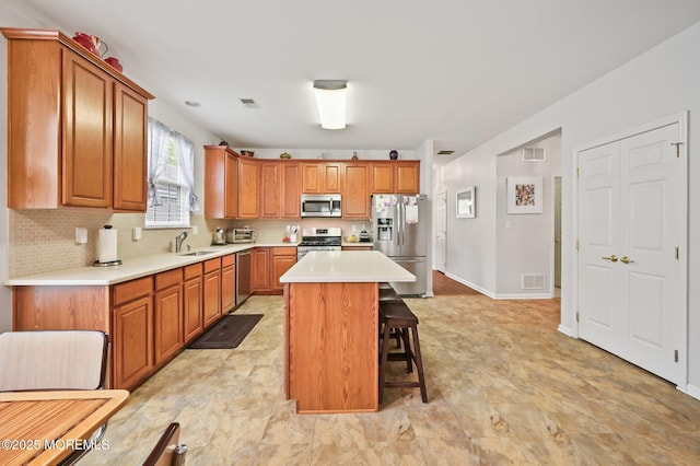 18 Hartack Rd, Manalapan, NJ 07726 - kitchen featuring appliances with stainless steel finishes, a sink, a kitchen breakfast bar, light countertops, and a kitchen island