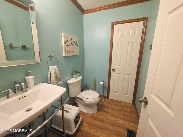 91 Grand Ave, Atlantic Highlands, NJ 07716 - bathroom with crown molding, visible vents, wood finished floors, toilet, and a sink