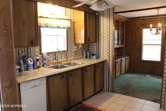 kitchen with a sink, a wealth of natural light, light carpet, and dishwasher