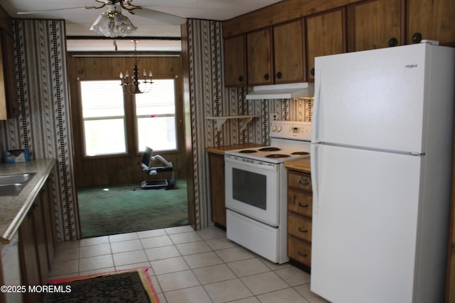 kitchen featuring light carpet, white appliances, light countertops, light tile patterned floors, and under cabinet range hood