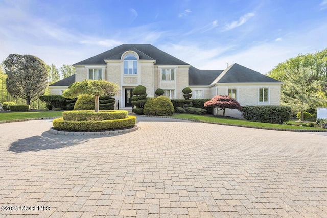 french country style house featuring curved driveway
