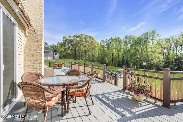 wooden terrace with a yard and outdoor dining space