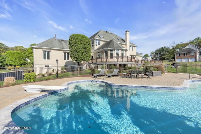 view of swimming pool featuring a fenced in pool, a diving board, a patio area, and fence