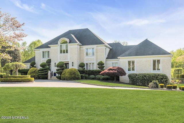 french provincial home with a front lawn