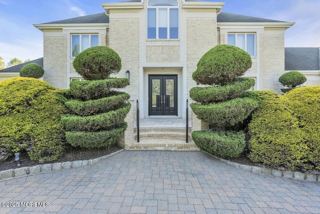 entrance to property featuring brick siding and french doors