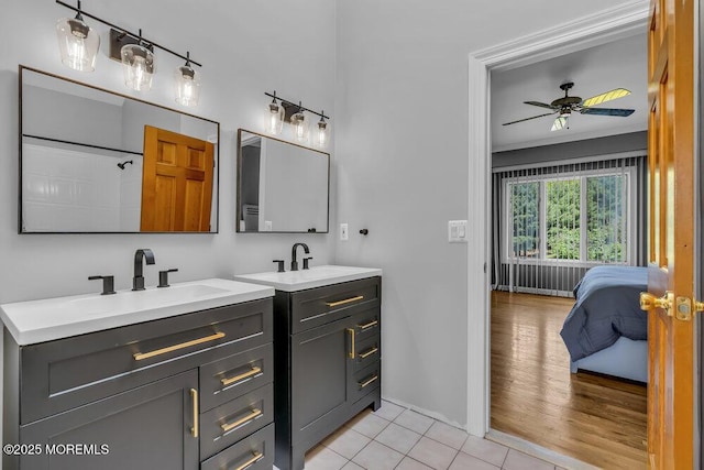bathroom with a ceiling fan, two vanities, a sink, and tile patterned flooring
