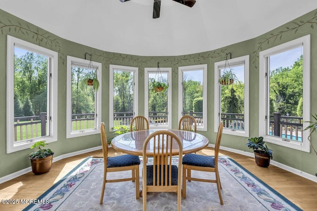 sunroom / solarium with baseboards and wood finished floors