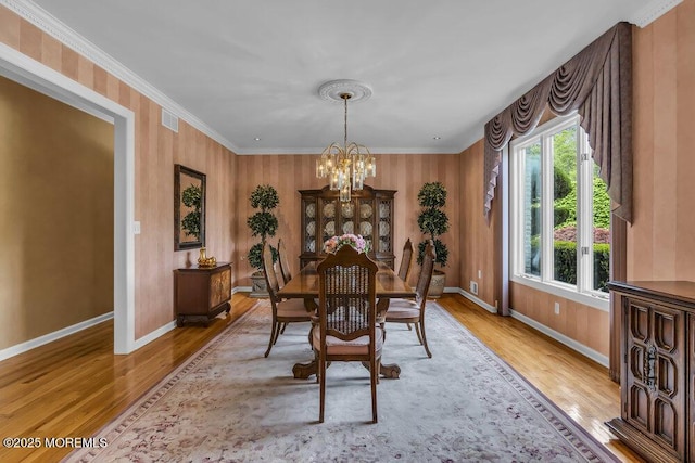 dining area with baseboards, a chandelier, wood finished floors, and visible vents