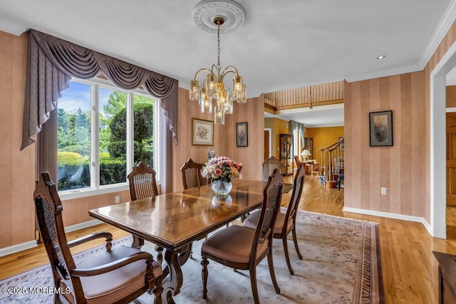 dining area featuring crown molding, light wood-type flooring, baseboards, a chandelier, and wallpapered walls