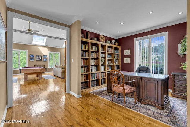 office space with light wood-type flooring, recessed lighting, crown molding, and a healthy amount of sunlight