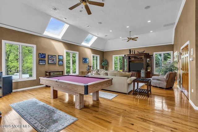 recreation room with ceiling fan, visible vents, a skylight, and light wood-type flooring
