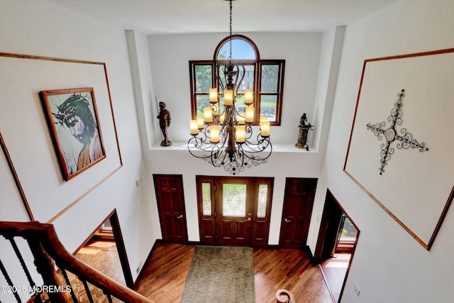 entrance foyer featuring a chandelier, wood finished floors, and a high ceiling