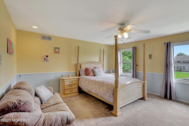 carpeted bedroom featuring multiple windows, a ceiling fan, and baseboards