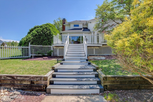 back of house with stairway, a chimney, and a deck