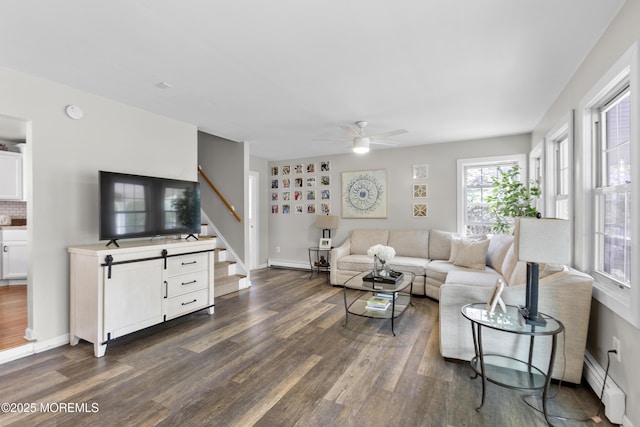 living room featuring baseboards, stairs, dark wood finished floors, and ceiling fan