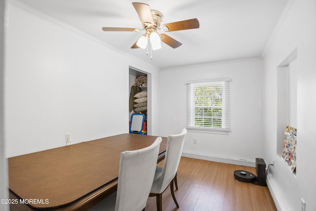 dining space featuring baseboards, ornamental molding, ceiling fan, and wood finished floors