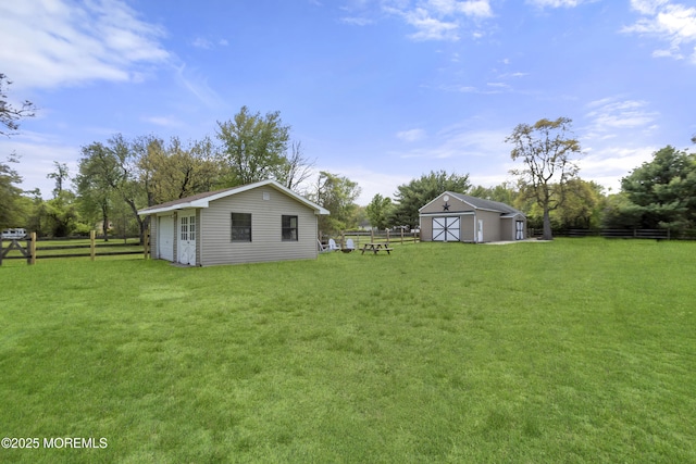 view of yard with fence and an outdoor structure