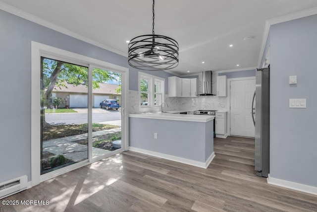 829A Westminster Ct, Manchester, NJ 08759 - kitchen featuring crown molding, a peninsula, wall chimney range hood, a chandelier, and stainless steel appliances