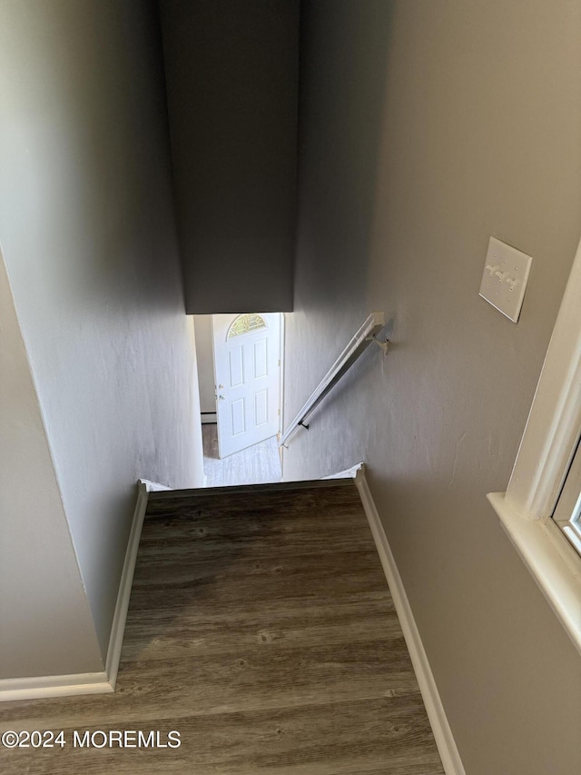 staircase with baseboards and wood finished floors