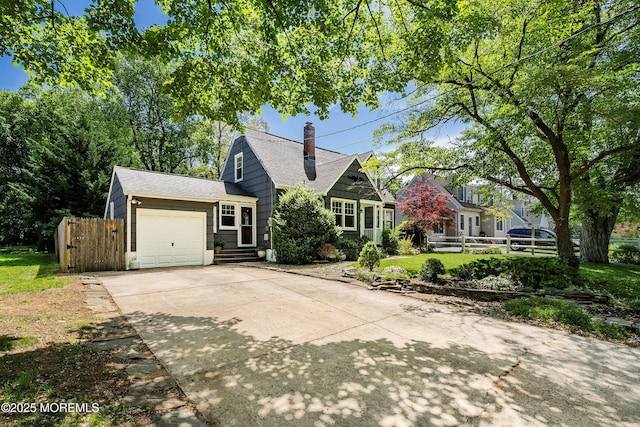 view of front of home with a garage, concrete driveway, a chimney, and roof with shingles