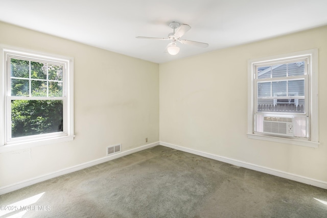 empty room with carpet floors, baseboards, cooling unit, and ceiling fan
