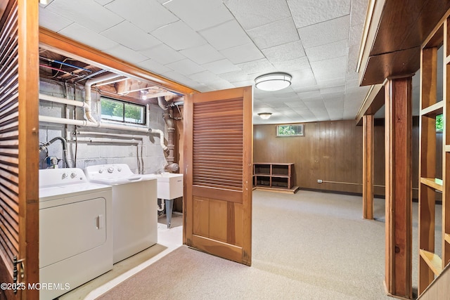 washroom featuring independent washer and dryer, wooden walls, healthy amount of natural light, and carpet floors