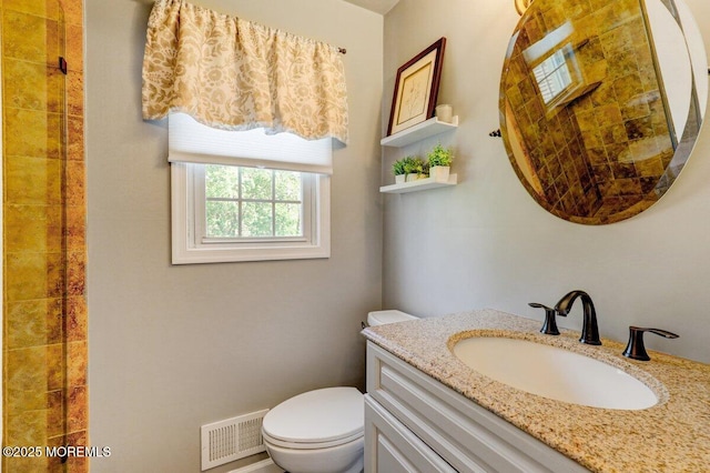 bathroom with toilet, vanity, and visible vents