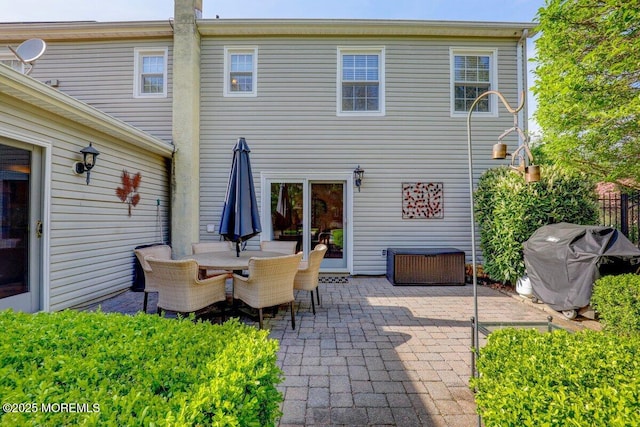 back of house with outdoor dining space and a patio
