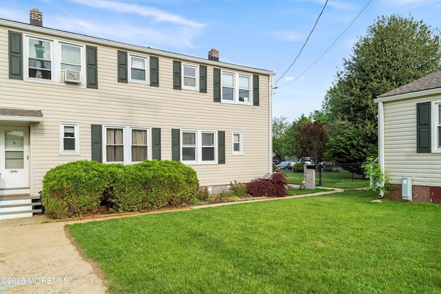 view of front of house with a chimney, a front lawn, cooling unit, and entry steps